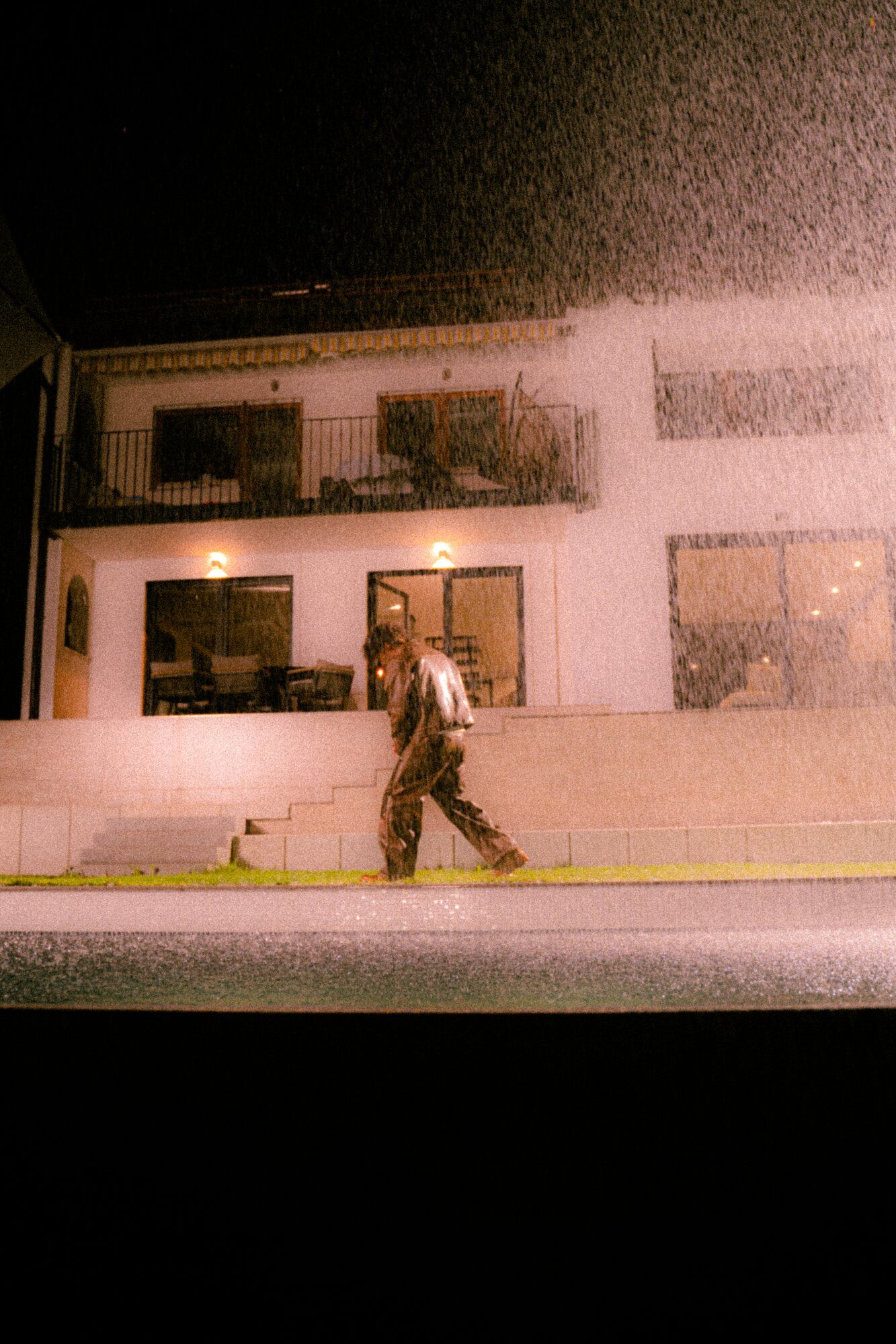 Nachtdreh im Regen vor einem Haus