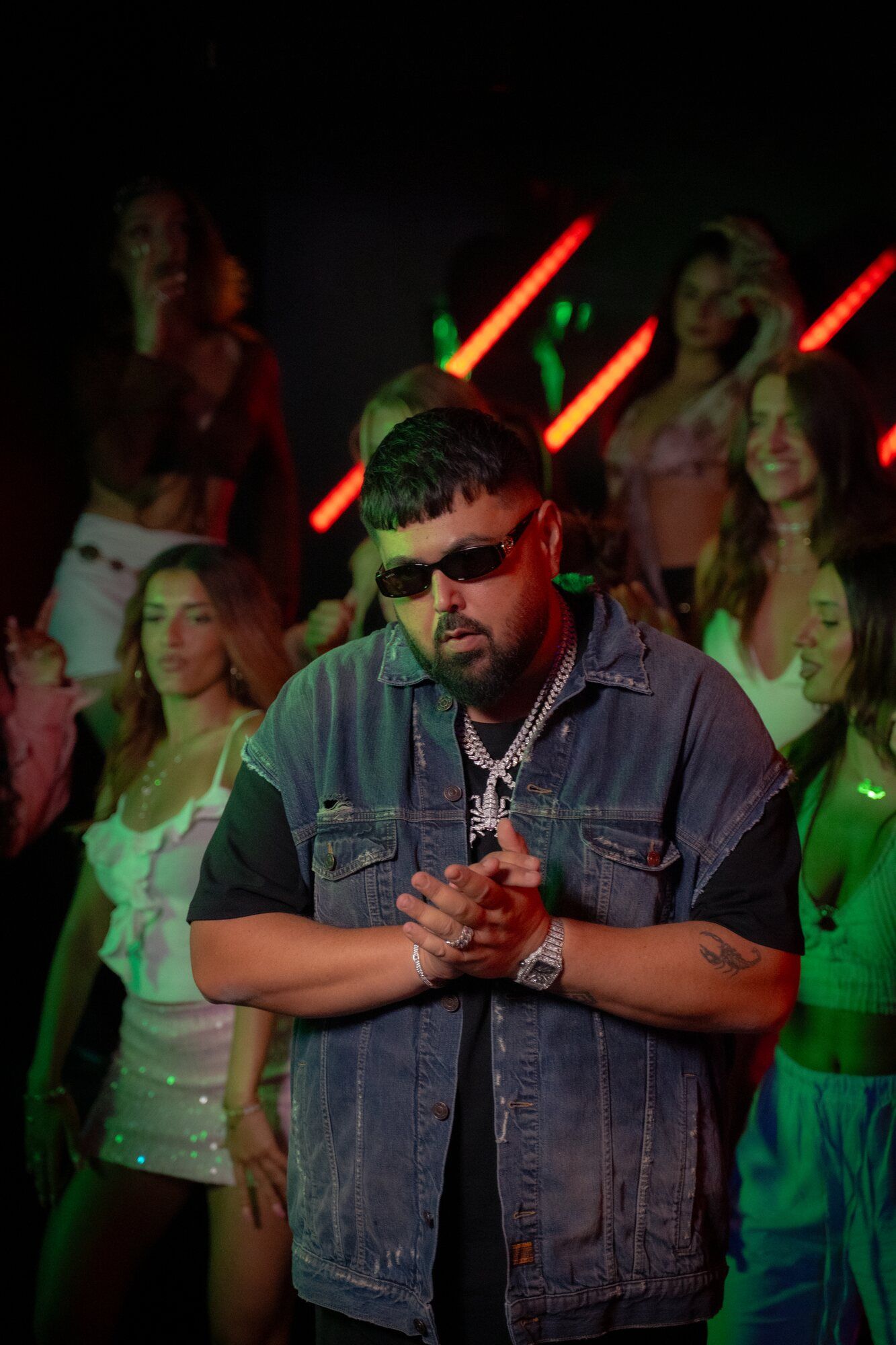 Rapper im Musikvideo-Set unter rotem Neonlicht
